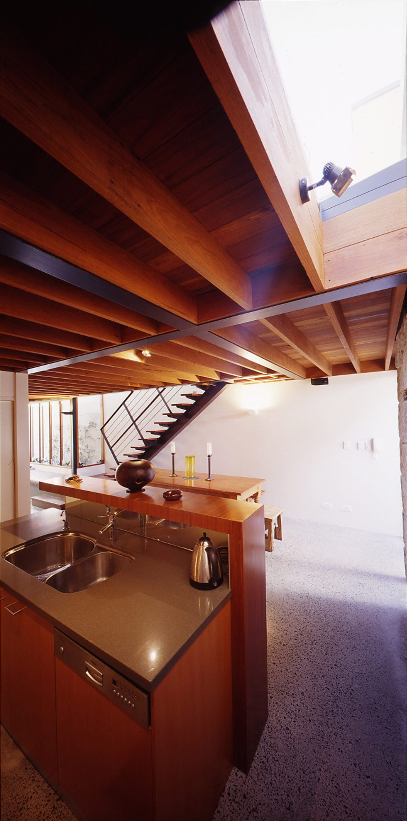 Bandi Drew House by Sydney award winning residential architecture firm Sam Crawford Architects. Exposed ironbark floor joists creates rhythm and provide character to the interior.
